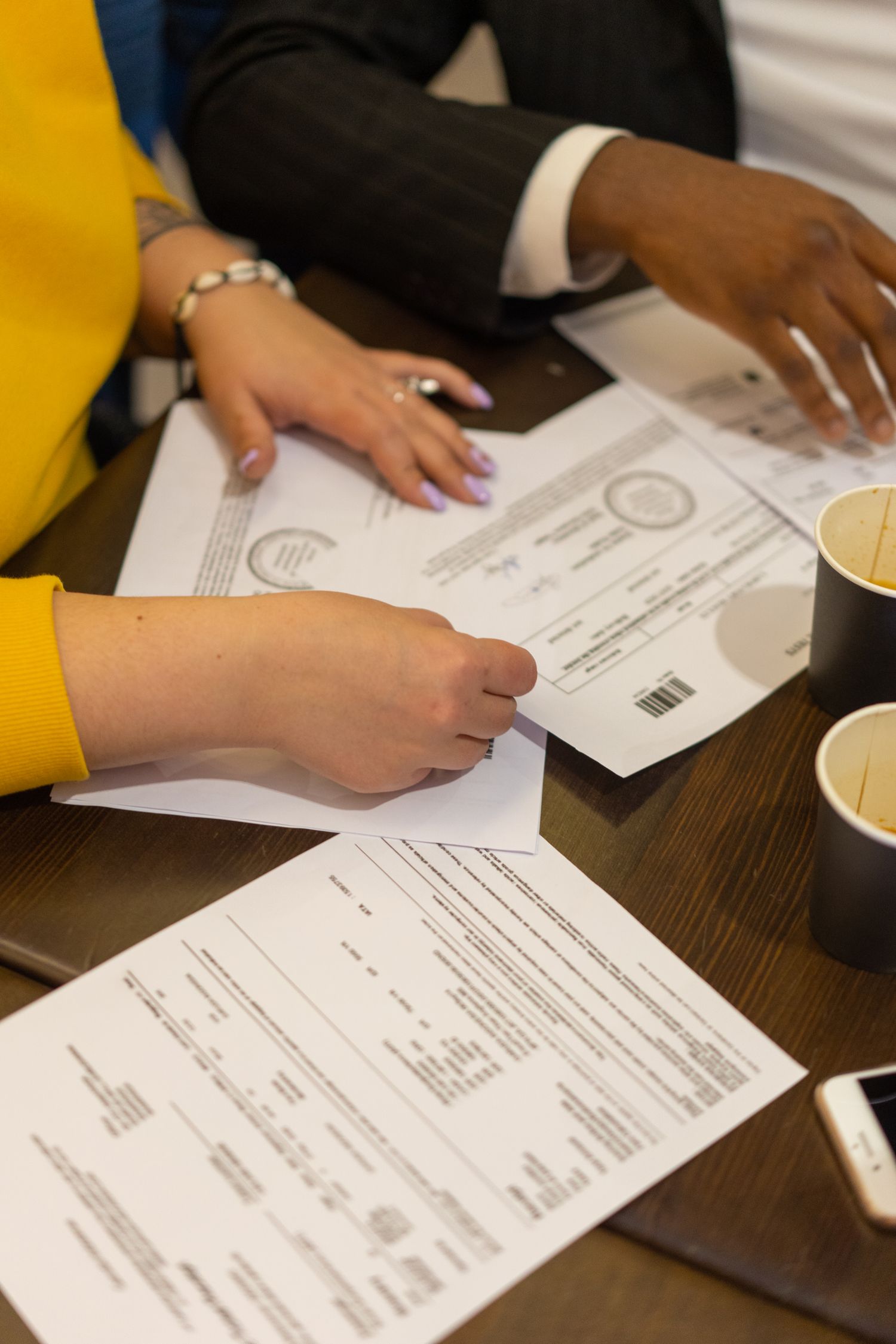 Hands reviewing documents at a discussion table